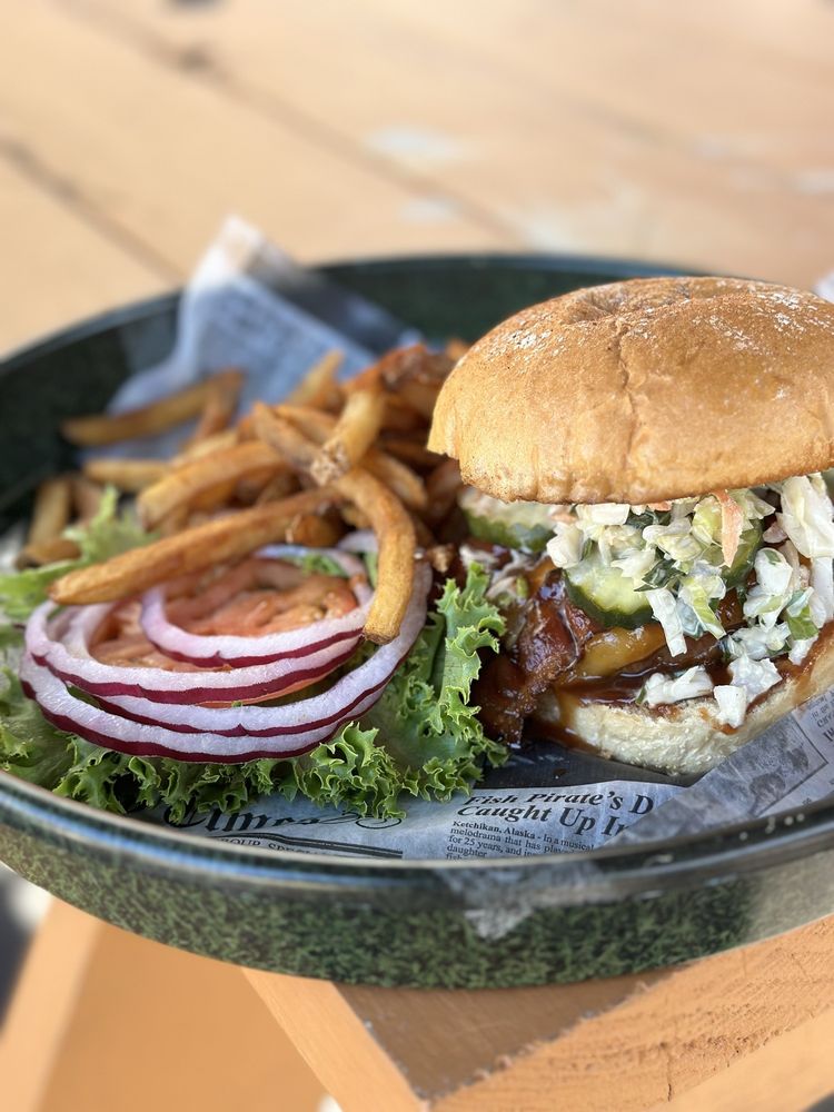 BBQ chicken sandwich with bacon and slaw served with fries, lettuce, tomato and red onion
