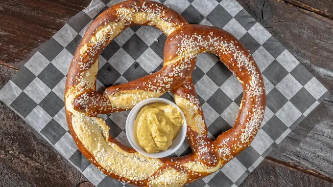 Giant soft pretzel with salt and a side of beer cheese mustard dip